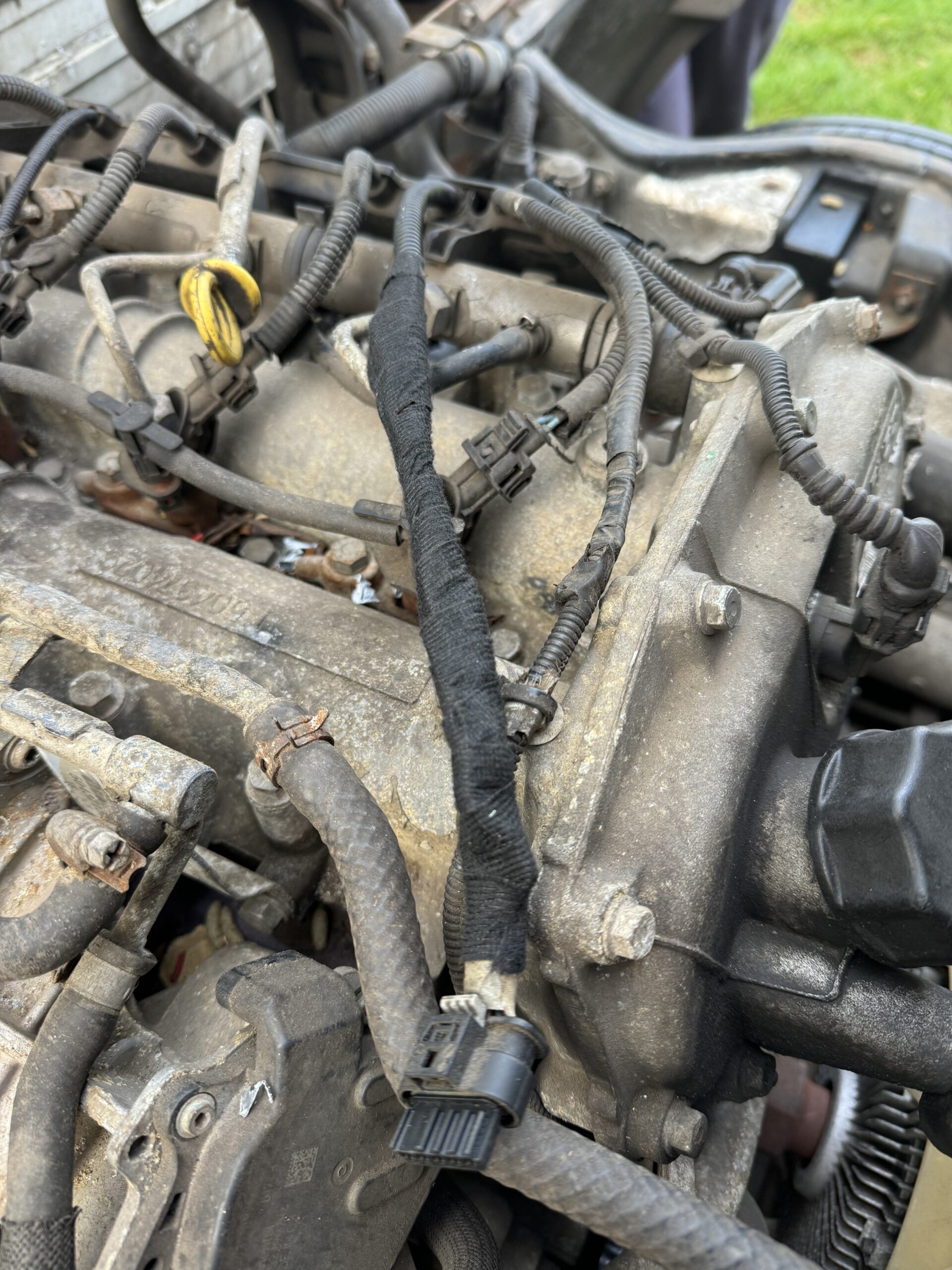 Close-up of repaired wiring in HGV engine bay — multiple wires spliced using inline connectors
